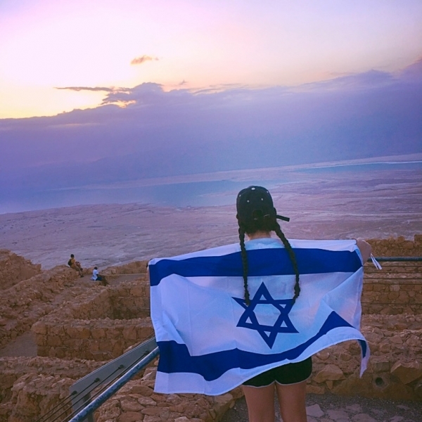 Arianna Kohan holding israel flag over her shoulders