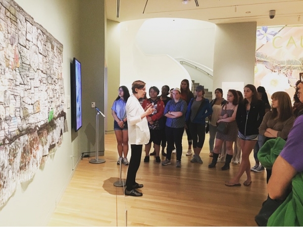 Presenter talking in front of group at museum