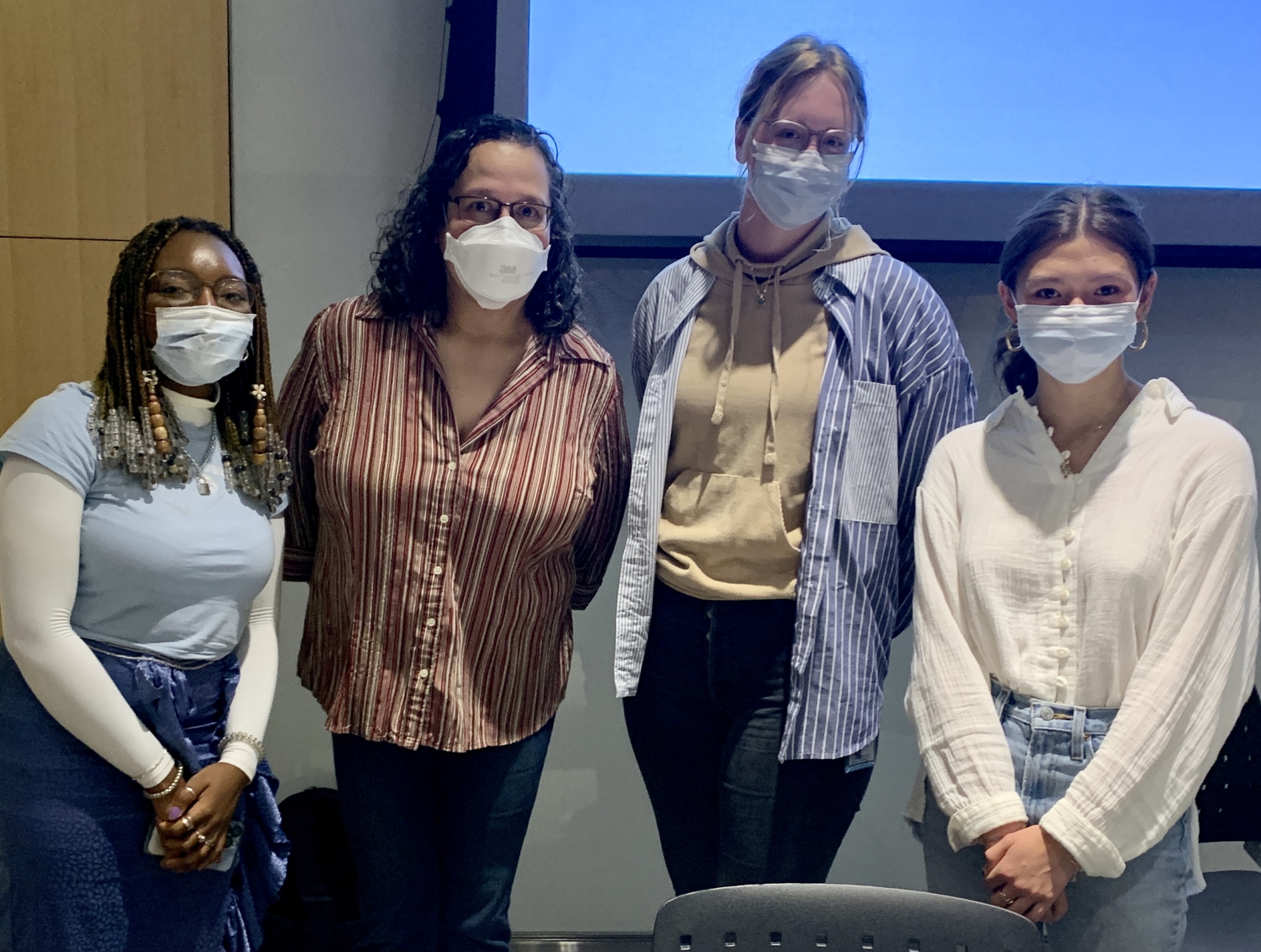 Four people together wearing masks
