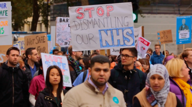Protest with the sign "Stop dismantling our NHS"