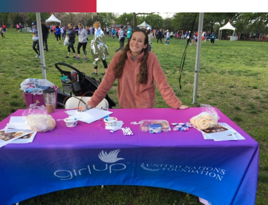 A woman tabling for Girl Up at an event